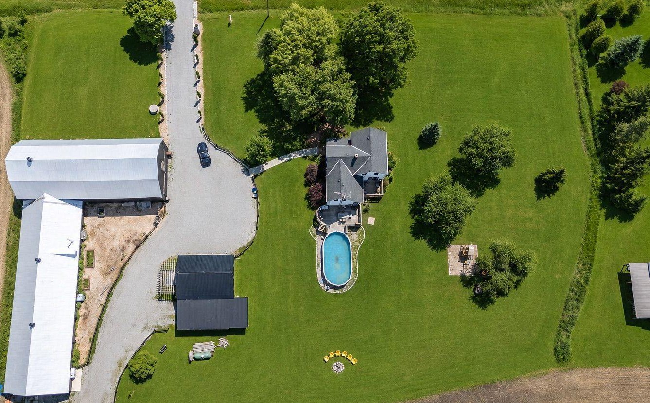 Overhead photograph of the property showing barn and workshop roofs, driveway, residence and grounds